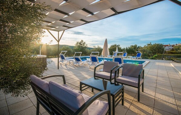 A poolside area with lounge chairs, a hot tub, and a pergola providing shade. - Pet friendly home in Radosinovci (Radosinovci)