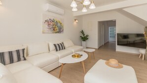 Een moderne woonkamer met een bank, salontafel en een televisie.
