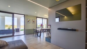 Un interno moderno con zona pranzo, ampie finestre e arredamento minimalista.