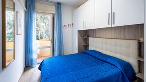 Une chambre à coucher avec un lit, une armoire et une fenêtre avec des rideaux.