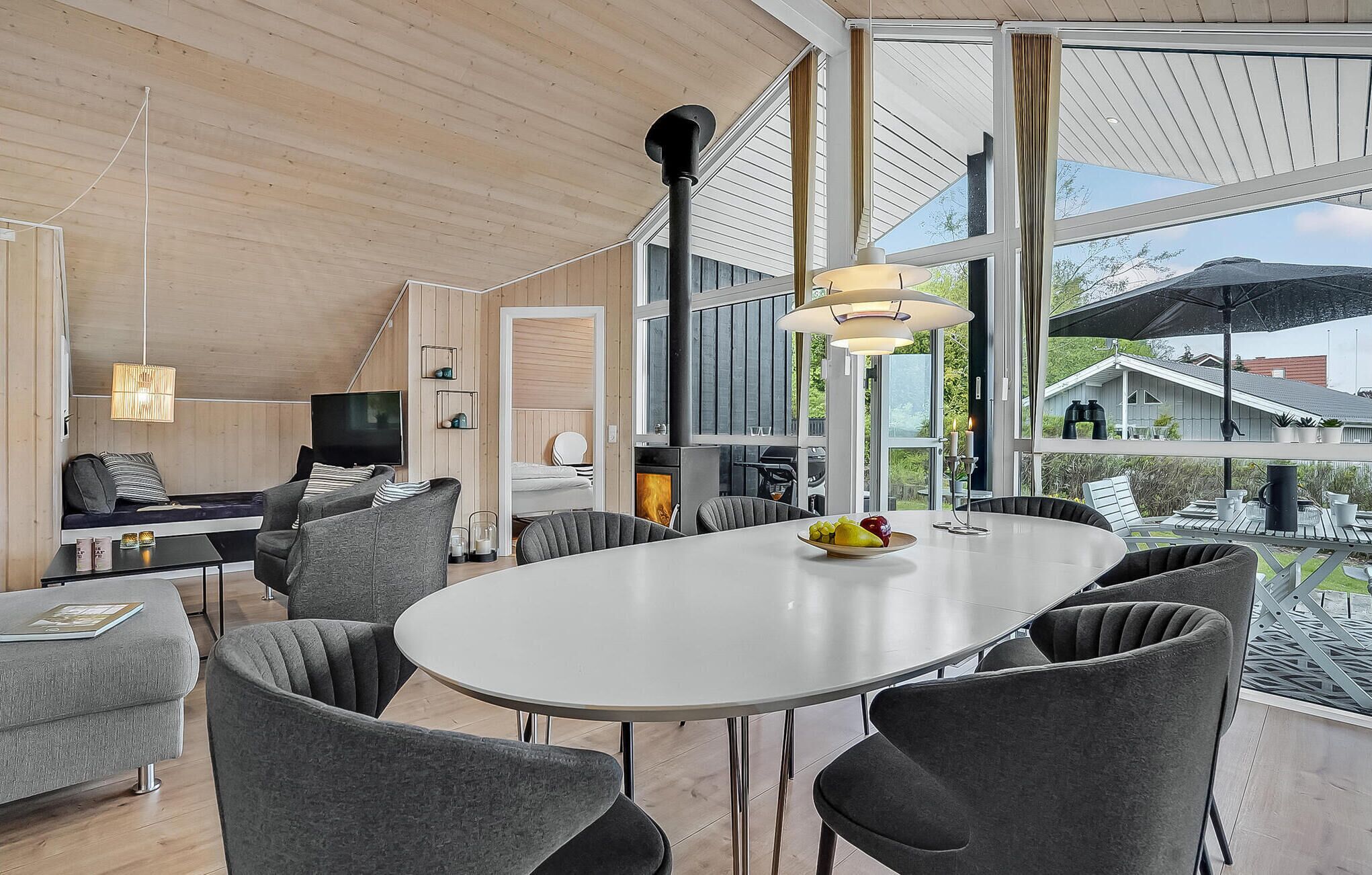 En modern inredning med ett stort matbord omgivet av stolar, en soffa och en tv i ett mysigt hörn.