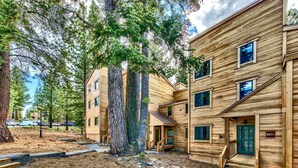 A multi-story wooden building with a front porch and a staircase leading to the entrance.