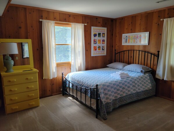 A bedroom with a bed, a dresser, a window with curtains, and wall art. - Spacious 6 Bedroom, 3000 sq ft, w/ NEW HOT TUB, close to the beach! (Corolla)