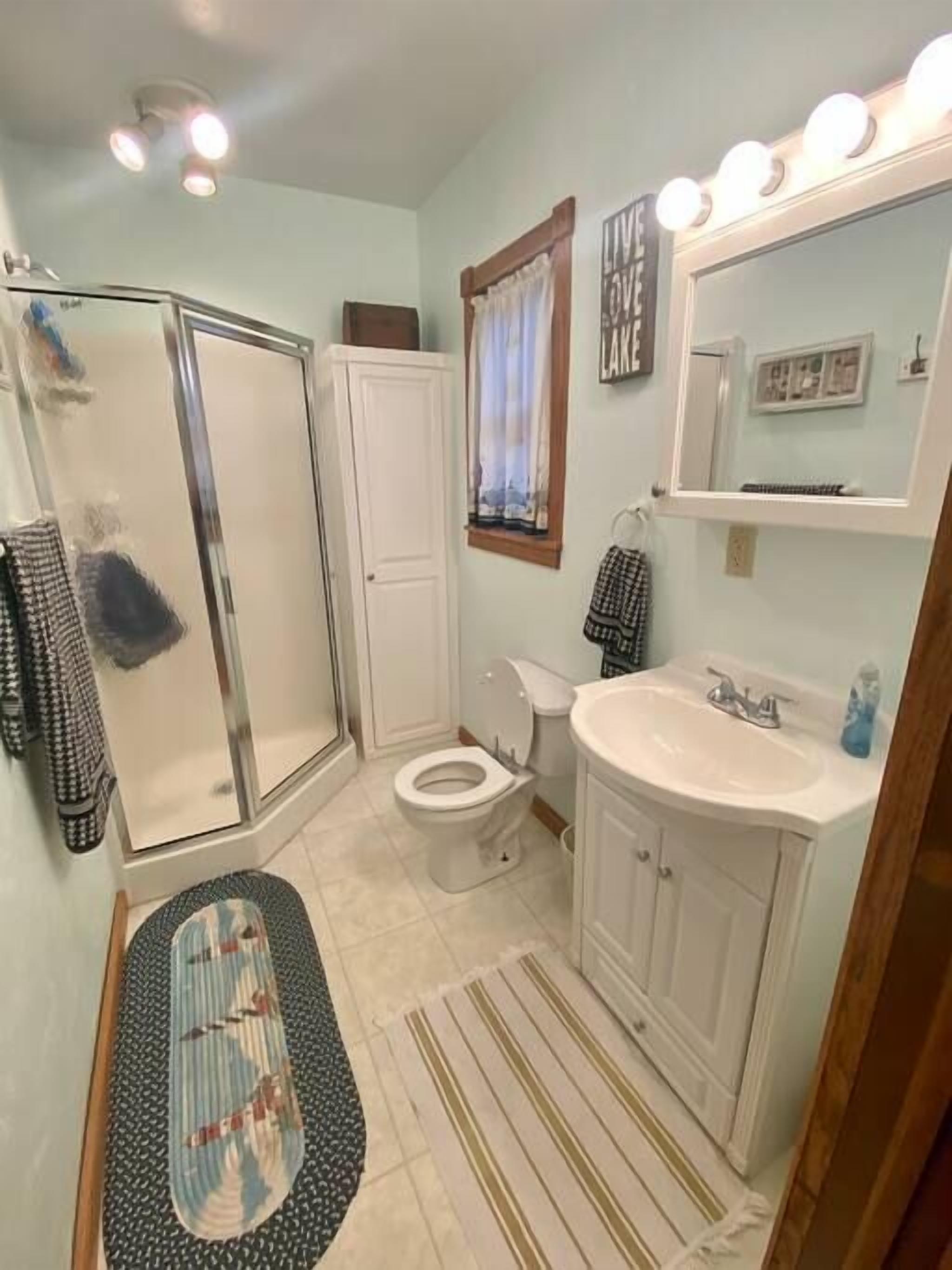 Une salle de bain équipée d’une douche, de toilettes, d’un lavabo et d’un meuble-lavabo.