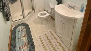 Une salle de bain équipée d’une douche, de toilettes, d’un lavabo et d’un meuble-lavabo.