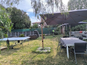 Un espace extérieur aménagé avec une table, des chaises, un canapé et un grand parasol.