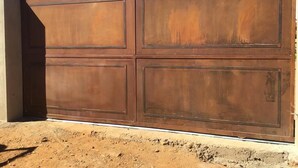 A large, rust-colored metal gate with a flat top and a rectangular design. - Casa Modular T2 (Quelfes)