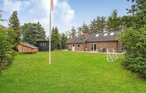 A brick house with a sloped roof and a small shed in the backyard. - 4 bedroom lovely home in Knebel (Knebel)