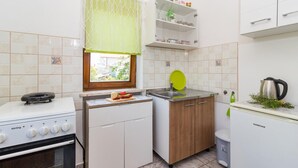 A compact kitchen with a stove, sink, and a small refrigerator. - Awesome Apartment in Valbandon With 1 Bedrooms and Wifi (Fazana)