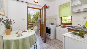 A compact kitchen with a dining area, a stove, and a sink. - Awesome Apartment in Valbandon With 1 Bedrooms and Wifi (Fazana)