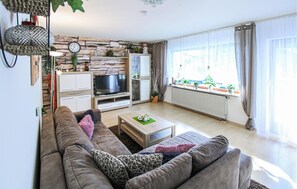 Relax in a spacious living room with a flat-screen TV, sofa, and coffee table.