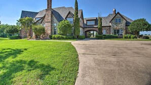 A large, multi-story house with a stone facade, a prominent chimney, and a well-maintained lawn. - Families Welcome! Lavish Celina Home w/ Game Room (Celina)