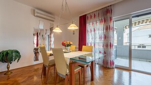 A dining area with a glass table, wooden chairs, and a hanging light fixture. - Stunning Apartment in Zadar With 2 Bedrooms, Wifi and Outdoor Swimming Pool (Zadar)
