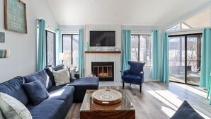 A living room with a sofa, armchair, and a fireplace. -  Beautiful Abbey Springs Gated Golf Cart Community with Beach, Pools, & Golf (Fontana-on-Geneva Lake)