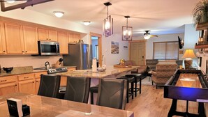A modern kitchen with wooden cabinets, stainless steel appliances, and a central island with bar stools. - Downtown Fun! A/C shufflebrd Pacman, Steps Fm SkiBus, DogOK, walk to Yampa River (Steamboat Springs)