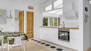 Une cuisine moderne avec un plan de travail en bois, des armoires blanches et un four encastré.
