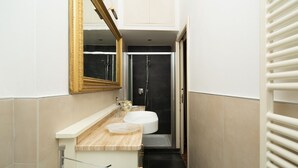 A narrow bathroom with a white sink, a mirror, and a shower. - Bardi Suite apartment near Ponte Vechhio by Mmega (Firenze)