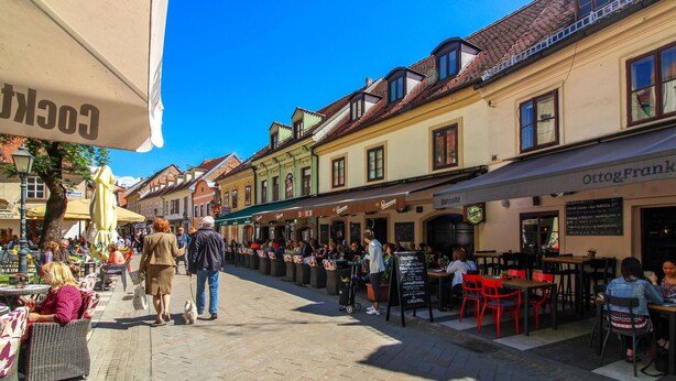 A bustling street with outdoor seating at cafes and restaurants, a clear blue sky, and traditional European architecture. - Awesome Apartment in Velika Gorica With 2 Bedrooms and Wifi (Velika Gorica)