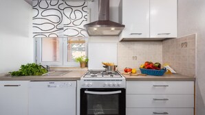 A modern kitchen with white cabinetry, a gas stove, an oven, and a window with a decorative pattern. - Stunning Home in Vizinada With 3 Bedrooms, Wifi and Outdoor Swimming Pool (Vizinada)