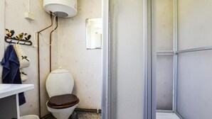 A small, compact bathroom with a toilet, a sink, and a shower area. - 2 bedroom lovely home in Slite (Slite)
