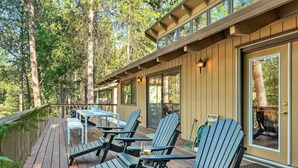 A deck with Adirondack chairs and a table, overlooking a forested area. - Pine Mountain Cabin w/ Hot Tub, 2 Mins to Marina! (Groveland)