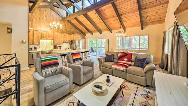 A spacious living area with a high ceiling, wooden beams, and large windows. - Pine Mountain Cabin w/ Hot Tub, 2 Mins to Marina! (Groveland)