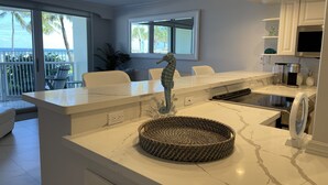 A modern kitchen with a marble countertop, a woven basket, and a seahorse decoration. - THE ONE! NEWLY RENOVATED GROUNDFLOOR BEACH/OCEAN FRONT CONDO with private deck! (Deerfield Beach)