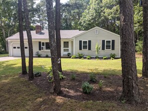 Stroll through the serene surroundings of this charming house, surrounded by a lush lawn and mature trees.