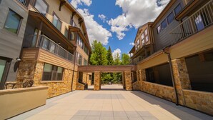 A courtyard with a covered walkway, stone walls, and multiple balconies.