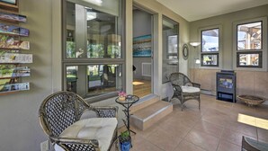 A spacious indoor area with wicker furniture, large windows, and a fireplace. - Serene Mountain Retreat w/ Patio & Mtn Views! (Cortez)