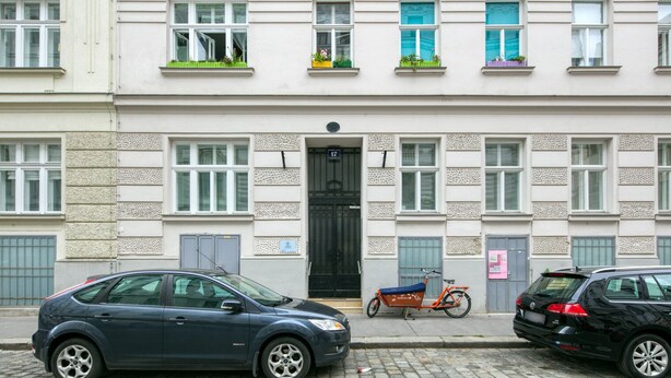 A row of townhouses with a black car parked in front, a bicycle, and a black car parked on the right. - Modern Brigittenau 1BR w/ AC, Elevator, near Metro U4, by Blueground (Vienna)