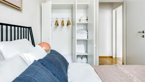 A bedroom with a bed, a wardrobe, and a door leading to another room. - Modern Brigittenau 1BR w/ AC, Elevator, near Metro U4, by Blueground (Vienna)