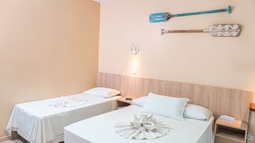 A hotel room with two beds, a wooden headboard, a wall-mounted telephone, and a wall-mounted light fixture.
