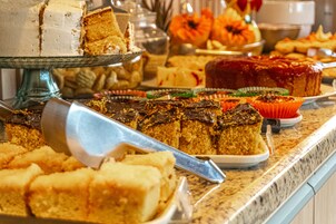 A buffet with various desserts including cakes and pastries.