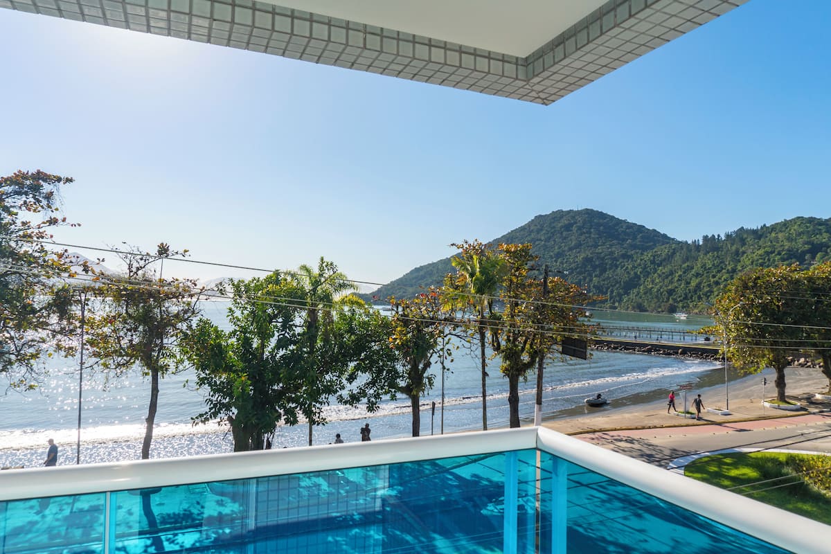 A pool area with a view of the beach and mountains.