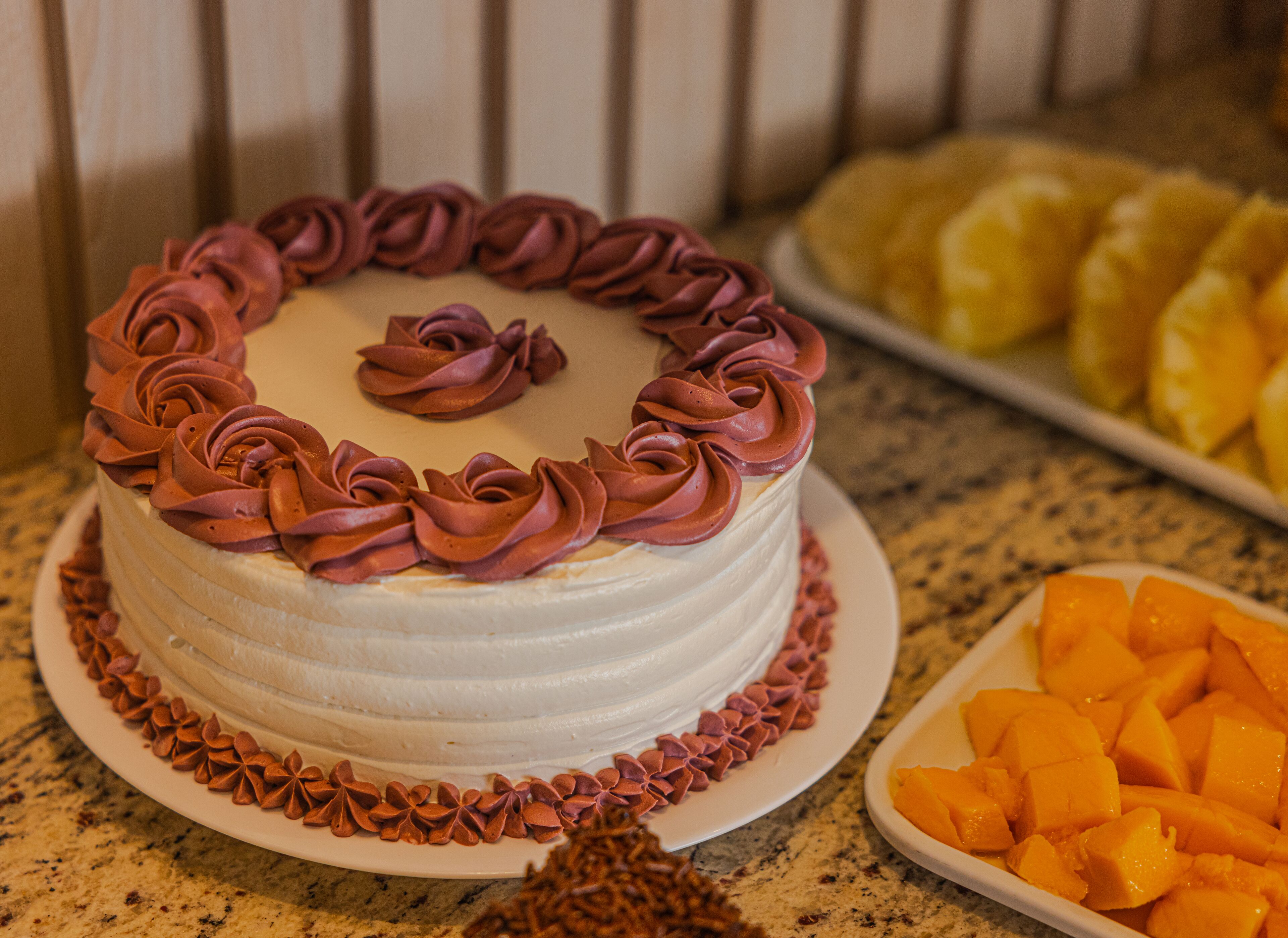 A cake with pink frosting on a plate.