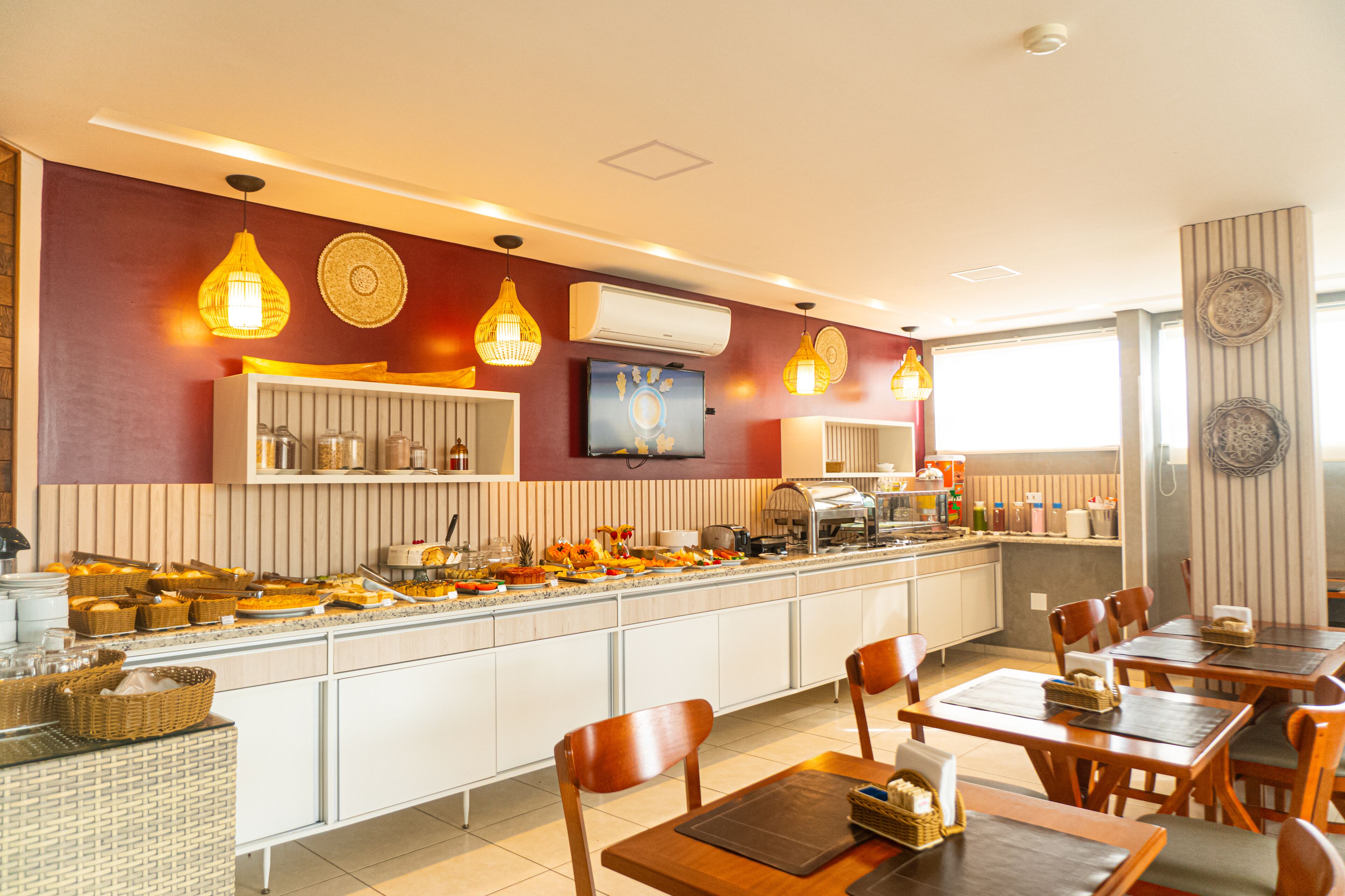 A buffet setup with various food items and a seating area with tables and chairs.