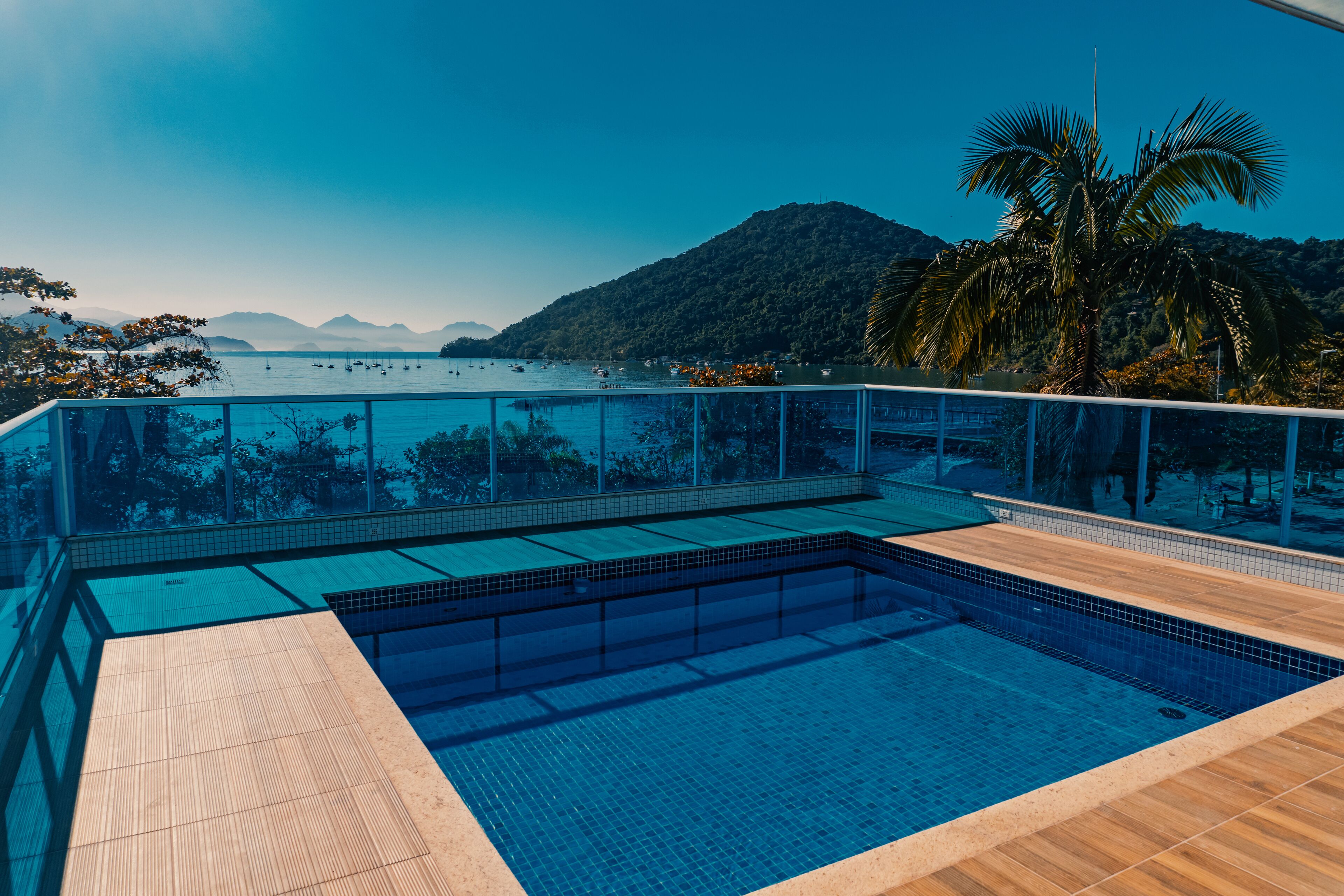 A swimming pool with a view of the sea and mountains.