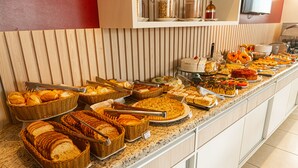 A buffet with various food items and utensils. - Ubatuba Praia Hotel (Ubatuba)