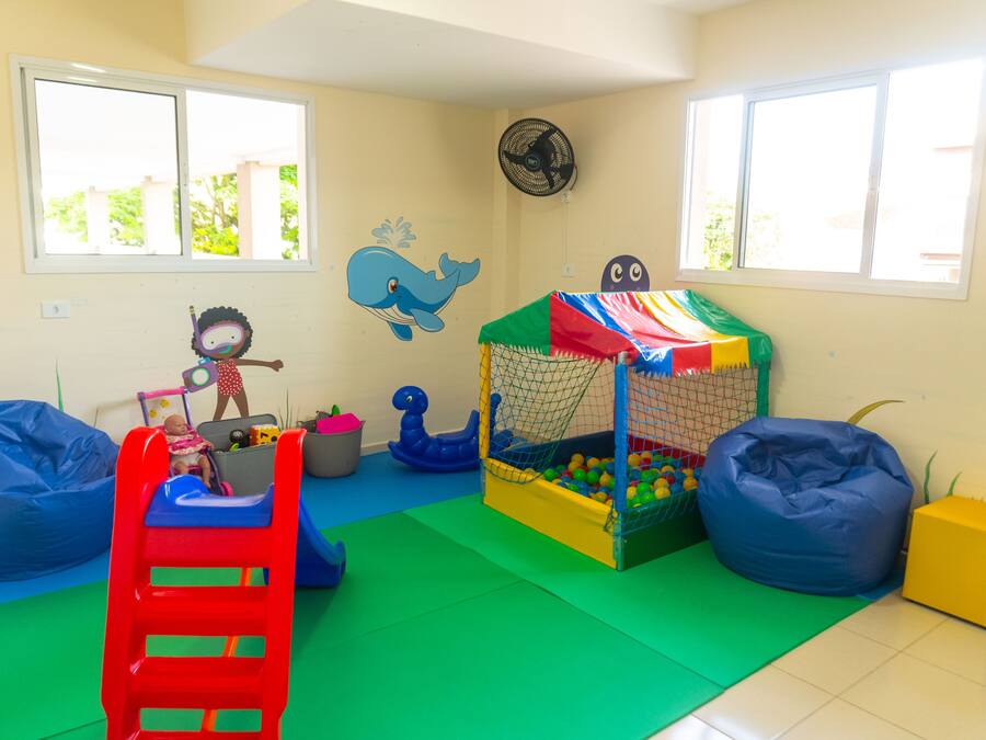 A playroom with a slide, ball pit, and colorful play structures.