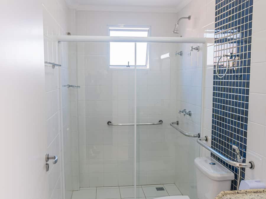 Un baño moderno con ducha de vidrio, inodoro y lavamanos con encimera de granito.