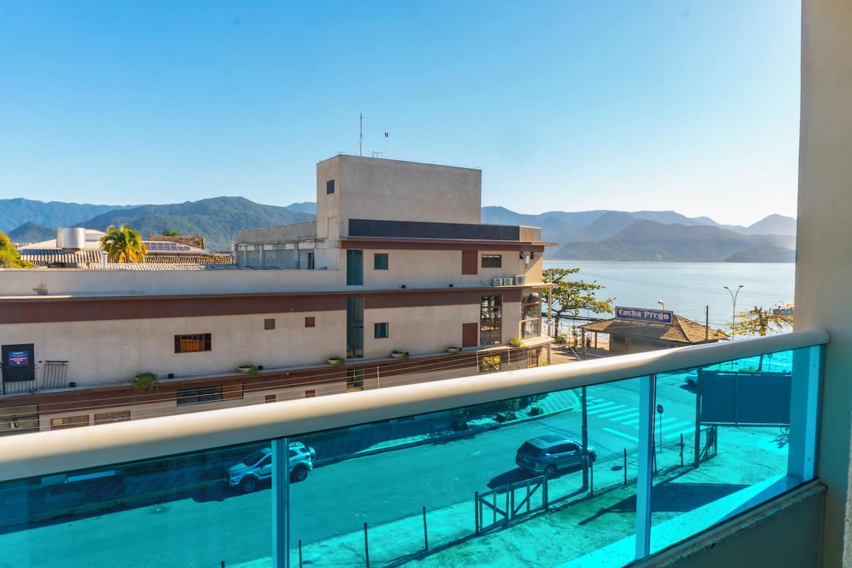 A modern hotel with a view of a body of water and mountains.