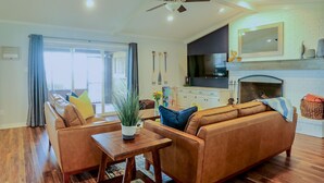 A spacious living room with a sofa set, a coffee table, and a fireplace.