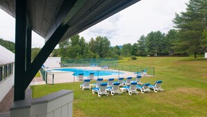 A swimming pool with blue chairs and a fenced area. - Private 2Bd 2Bath - Sleeps 5/6 Town home In Stowe VT - 15min From The Mountain (Stowe)