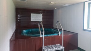 A small, enclosed hot tub area with a wooden wall and a sign providing safety instructions. - Private 2Bd 2Bath - Sleeps 5/6 Town home In Stowe VT - 15min From The Mountain (Stowe)