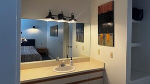 A bathroom with a mirror, sink, and artwork on the wall. - Private 2Bd 2Bath - Sleeps 5/6 Town home In Stowe VT - 15min From The Mountain (Stowe)