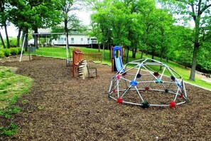 Un parque infantil con columpios, tobogán y estructura para escalar.