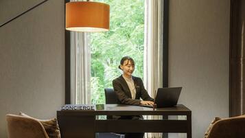 A hotel room with a desk, a laptop, and a nameplate reading "CONCIERGE".