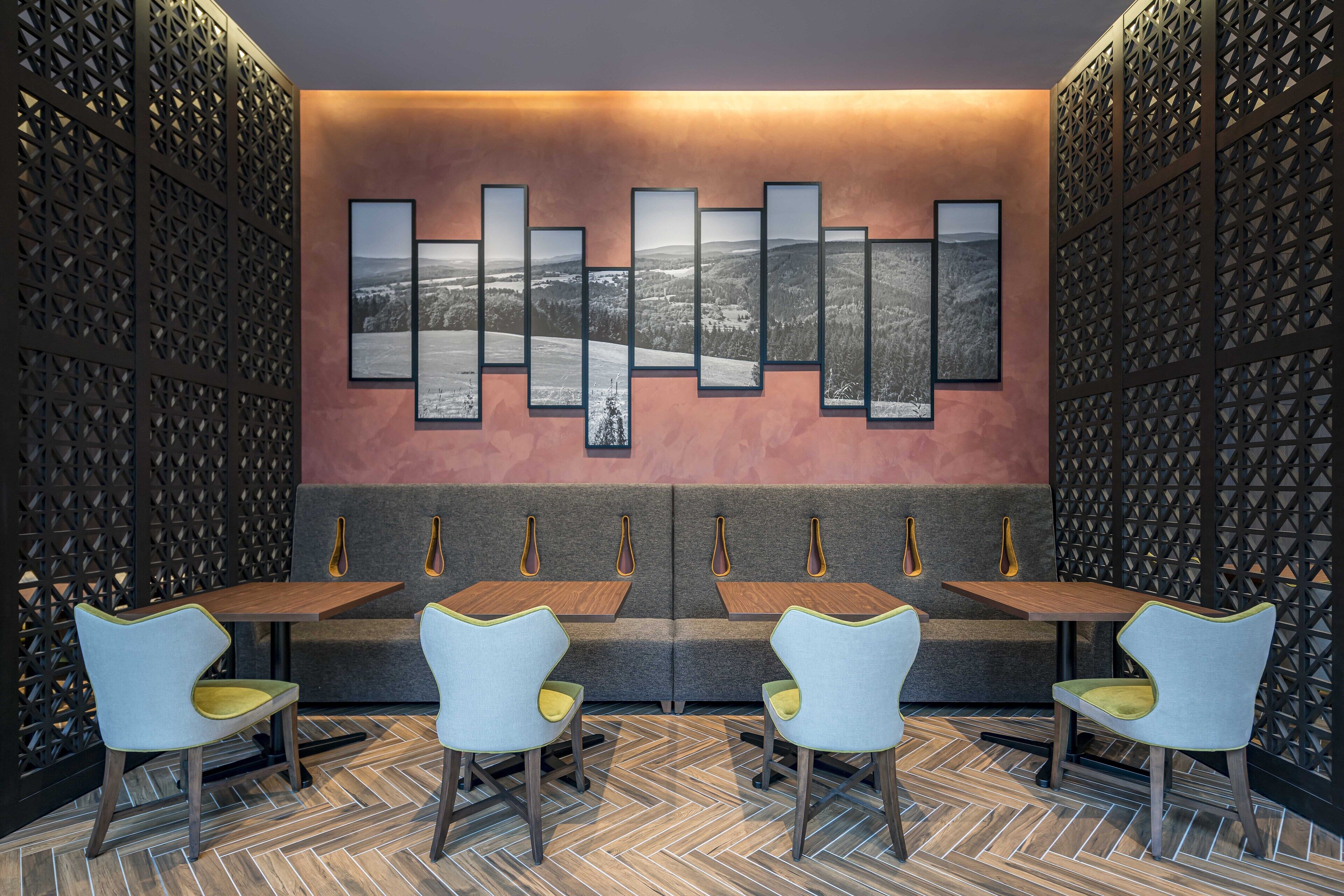 Un área de comedor moderna con piso de diseño en espiga, un banco como asiento y una obra de arte colgada en la pared.