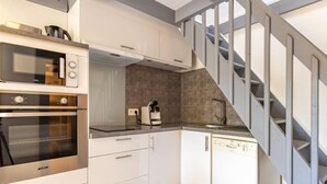 A modern kitchen with built-in ovens, a coffee machine, and a dishwasher.